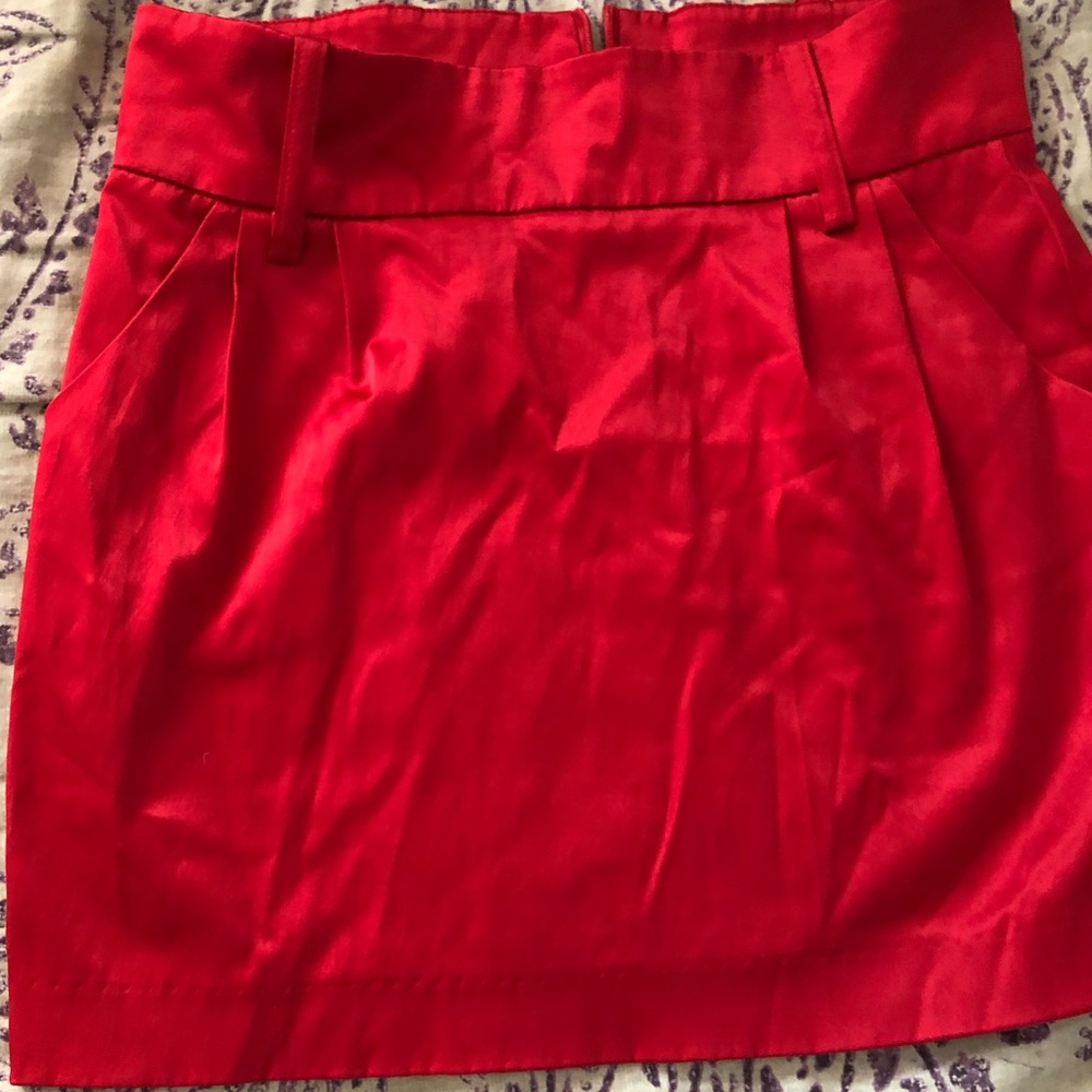Red silky/shiny skirt.
